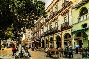 una calle de la ciudad con mesas, sillas y edificios en Hotel Imperial en Veracruz
