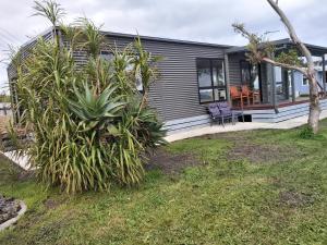 a house with a patio and plants in front of it at Sunset View Villa in Apollo Bay