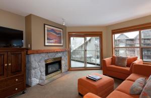 a living room with a fireplace and a tv at The Aspens by Whistler Premier in Whistler