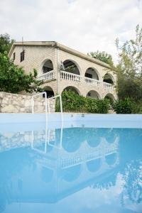 a swimming pool in front of a building at Village house Vrelo in Mandići