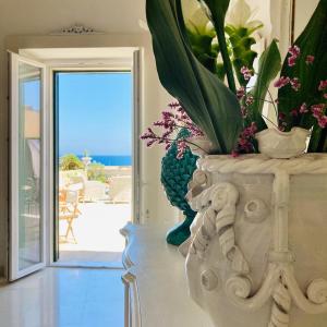 a vase with flowers in it sitting on a table in a room at Palazzo De Mori in Otranto