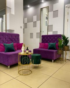 a room with purple couches and a table and a mirror at Boutique hotel Statler in Biysk