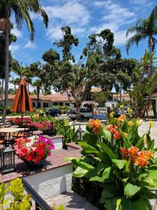 un jardín con flores, mesas y sillas en Marina Beach Motel, en Santa Bárbara