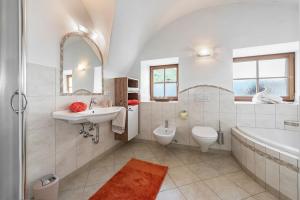 La salle de bains est pourvue d'un lavabo, d'une baignoire et de toilettes. dans l'établissement Sigmundhof, à Bressanone