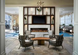 a living room with a fireplace and a table and chairs at Hotel Indigo San Diego Del Mar, an IHG Hotel in San Diego