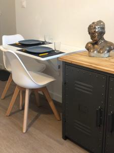 a table with a chair and a desk with a statue at Le studio d'Angèle : Angie in Bruz