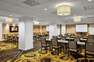 a conference room with tables and chairs and a screen at Kimpton Hotel Monaco Denver, an IHG Hotel in Denver