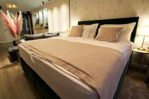 a large bed with white sheets and pillows in a bedroom at Apartman My Story in Osijek +37 photos