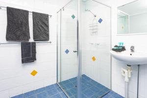 a bathroom with a shower and a sink at Airlie Sun & Sand Accommodation #6 in Airlie Beach +20 photos