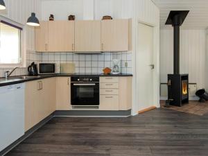 een keuken met witte kasten en een fornuis bij 8 person holiday home in Ringk bing in Søndervig