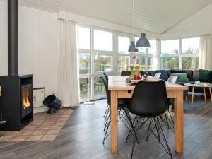 een woonkamer met een tafel en een open haard bij 8 person holiday home in Ringk bing in Søndervig