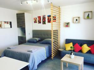 a bedroom with a bed and a blue couch at Suite Athéna - Melun gare RER - Studio avec Balcon et parking in Melun