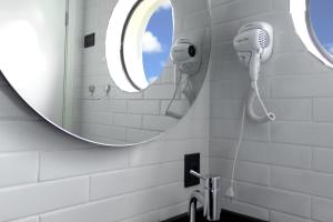a bathroom with a mirror and a blow dryer at Castro's Hotel in Telêmaco Borba