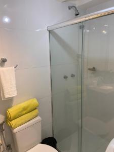 a bathroom with a shower and a toilet with a yellow towel at Vila Noel Premium in Penedo +59 photos