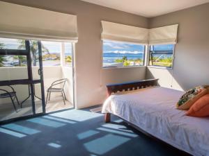 カイテリテリにあるSun, Sea, Sensational - Kaiteriteri Holiday Homeのベッドがあり海が見える寝室