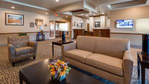 un soggiorno con divano e tavolo di Best Western El-Quartelejo Inn & Suites a Scott City