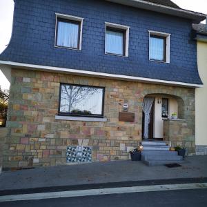 een stenen huis met een blauw dak bij Ferienhaus Neuville in ruhiger Lage in Bullange