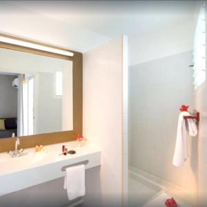 bagno con lavandino e specchio di STUDIO LUANA a Belle-Allée