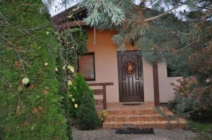 una casa con una puerta negra y escaleras delante en Dworek - Polna, en Skrzeszew