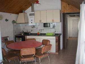 uma cozinha com uma mesa e cadeiras numa cozinha em Cabaña Las Candelas em Potrerillos
