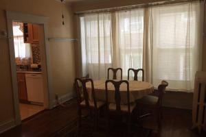 a dining room with a table and chairs and a kitchen at 3 Bedroom Apartment steps to Clifton, Zoo, UC, Hospitals in Cincinnati