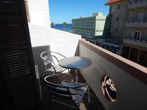 Una mesa y dos sillas sentadas en un balcón. en Hotel Timbó, en Piriápolis
