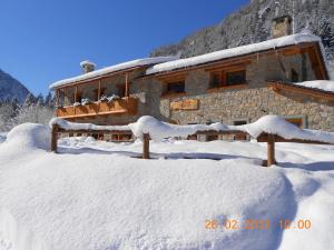 a building covered in snow in front at Agriturismo Alle Baite in Branzi