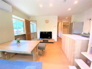 a kitchen with a wooden table and a dining room at 白馬パウダーマウンテン in Hakuba