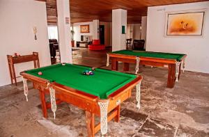 duas mesas de bilhar sentadas numa sala com em Hotel Suiça Faber em Balneário Camboriú