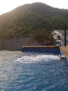 a swimming pool with a wave in the water at Mogan Mountain Xiaomusensen in Deqing