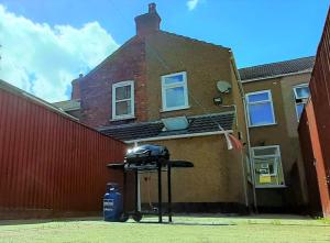 une table noire devant un bâtiment en briques dans l'établissement Grimsby-Cleethorpes Sleeps 7, à Grimsby