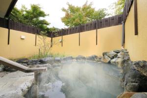 a pool of water next to a fence at Yumori Kamaya in Nikko