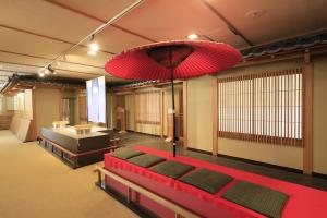 Habitación con cama roja y lámpara de araña grande. en Yumori Kamaya en Nikko