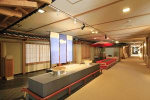 una sala de espera con bancos y una sombrilla roja en Yumori Kamaya en Nikko