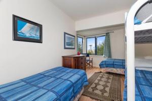 a bedroom with two beds and a desk and a window at Taste Of Paradise with WiFi!- Mangawhai Heads Home in Mangawhai +16 photos