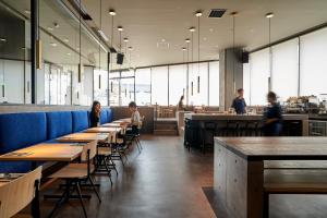 a restaurant with wooden tables and people sitting at tables at THE REIGN HOTEL KYOTO in Kyoto