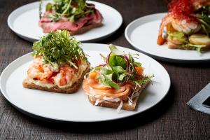 four white plates with sandwiches on a table at THE REIGN HOTEL KYOTO in Kyoto