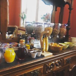 a buffet of breakfast foods and drinks on a table at King William IV Guest House in Settle