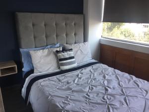 a bedroom with a large bed with a large headboard at Blue Dreams Apartament Del Valle in Mexico City