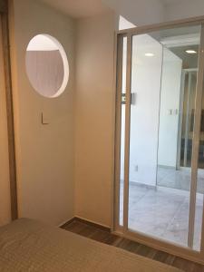 a bedroom with a glass door leading to a walk in shower at Blue Dreams Apartament Del Valle in Mexico City +13 photos