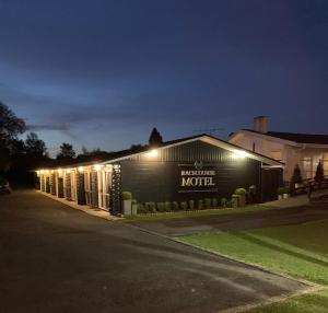 un edificio con un cartel que lee motel por la noche en Racecourse Motel, en Paeroa