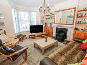 a living room with a fireplace and a tv at Dovedale in Ryde