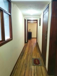 an empty hallway with a door and wooden floors at LA CASA DEL CENTRO in Quito