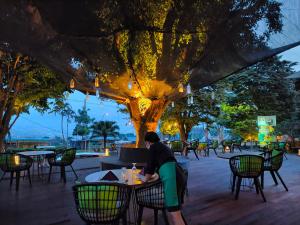 バトゥにあるThe Batu Hotel & Villasの夜のレストランのテーブルに座る者