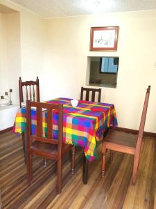 a dining room table with a colorful table cloth and two chairs at LA CASA DEL CENTRO in Quito