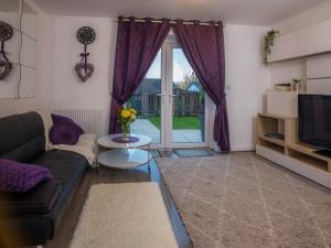 a living room with a couch and a sliding glass door at Modern 2 Bed House with Parking and Garden in Nottingham