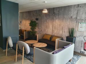 a living room with a couch and tables at B&B HOTEL Ouistreham in Ouistreham
