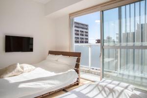 a bedroom with two beds and a large window at Apartment HOTEL KIRO Kyoto STATION in Kyoto