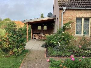 Casa con patio con mesa y sillas en Cottage, en Buchholz