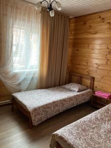 ゼリョンナヤ・ポリャナにあるотель Емеляのベッドルーム1室(ベッド2台、窓付)